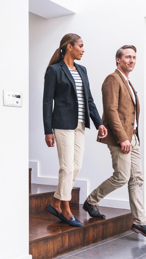 Crestron touch panel in a wall. Two people coming downstairs